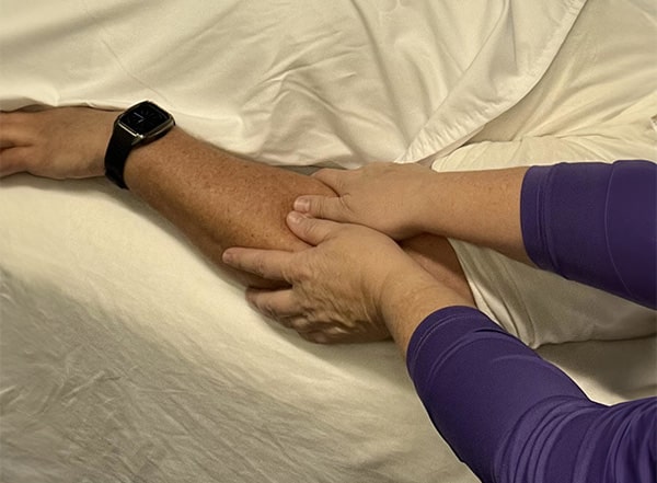 Therapist gently performing cranial sacral therapy to release tension and promote relaxation